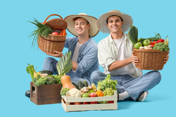 Male farmers with fresh vegetables on blue background