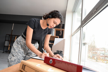 Female African-American soldier working with headset at headquarters