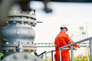 a man worker engineer conducts a site inspection at an industrial facility of gas and oil petroleum...