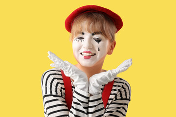 Female pantomimist on yellow background