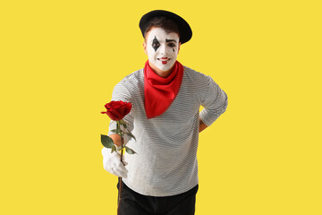 Male pantomimist with rose on yellow background