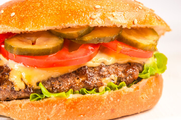 Classic cheeseburger with lettuce, tomatoes, and pickles.