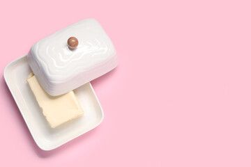 Ceramic dish with fresh butter on pink background