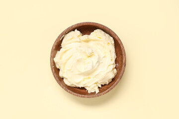 Wooden bowl with fresh butter on color background
