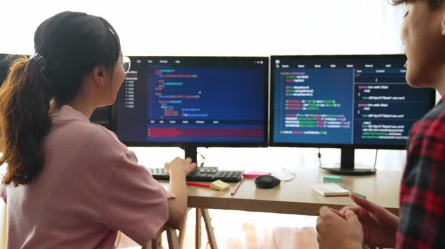 Slow motion back end software developer engineer for computer programming working together on debugging writing computing code, solving complex algorithms display on monitor in office. Burgeoning