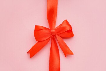 Beautiful bow made of red ribbon on pink background