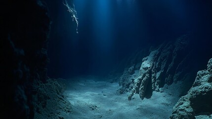 Obraz premium The image explores the dark depths of the Mariana Trench, with steep rock formations on the seabed. The mysterious and imposing environment reveals the grandeur of the ocean.