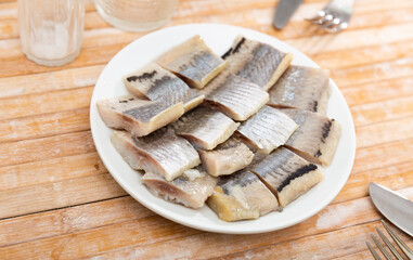 Traditional scandinavian delicacy, salted young herring fillet on the plate