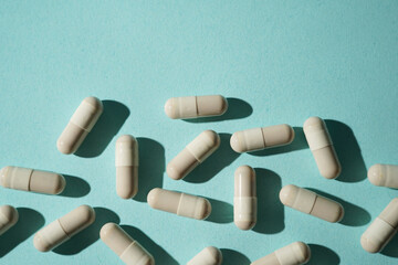 Group of pills capsules, the nutritional supplements, vitamins medicine tablets on blue background