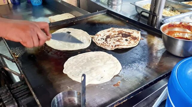 Paratha bread seller cooks bread from dough at his stall