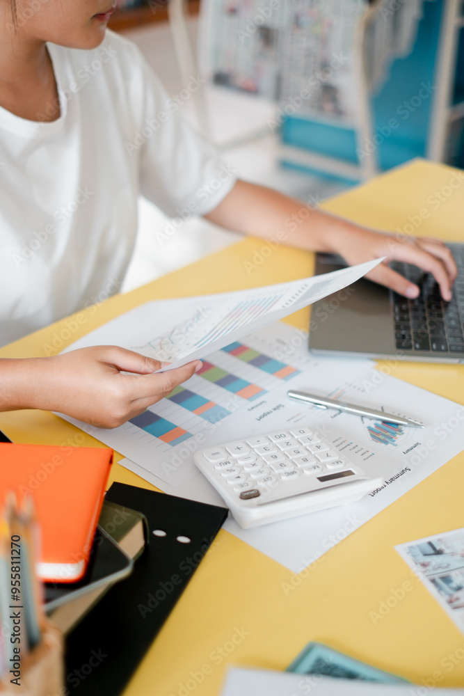 Poster close-up of a business professional analyzing financial reports and data on a laptop at an office de