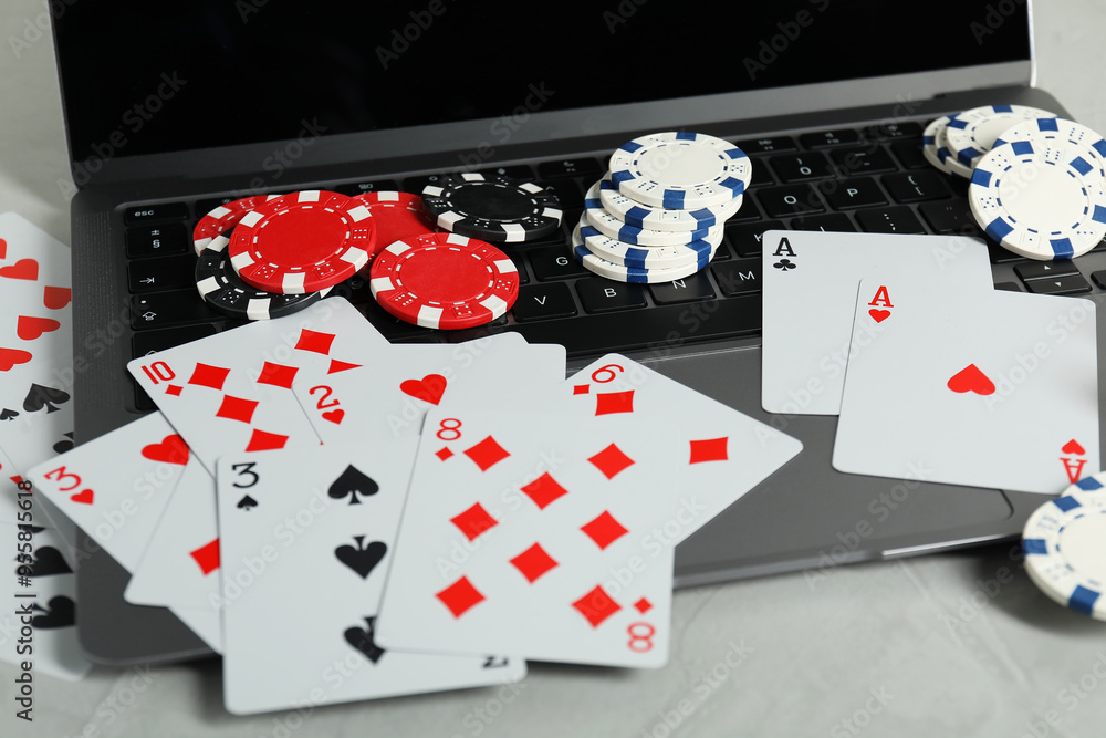 Wall mural Online poker. Playing cards, chips and laptop on light grey table