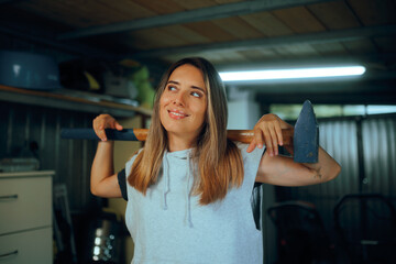 Happy Girl with a Big Hammer Ready for Home Chores. Strong woman trying a do it yourself remodeling...