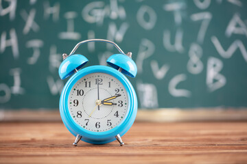 Alarm clock in front of blackboard background