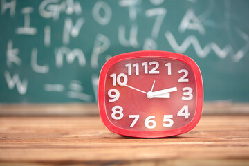 Alarm clock in front of blackboard background