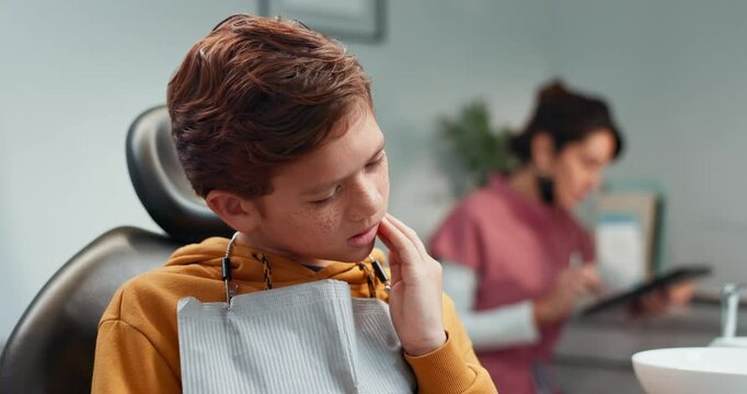 Toothache, child and dentist assistant for procedure progress in hospital, oral care clinic or office. Kid, consultation and pain with dental hygienist for cleaning, root canal treatment or braces