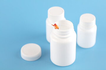 Miniature creative people crawling out of the medicine bottle