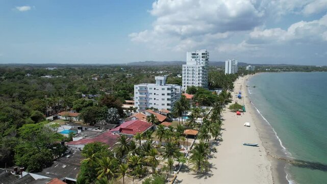 vista de dron de la playa con edificios y vegetaci&oacute;n