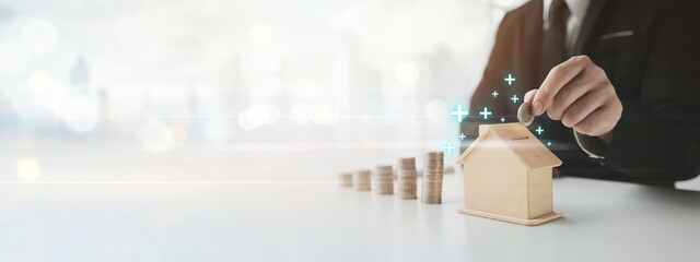 Person with savings for real estate purchase, personal financial planning concept of income allocation, expenses and investment, businessman with pile of coins and house model.