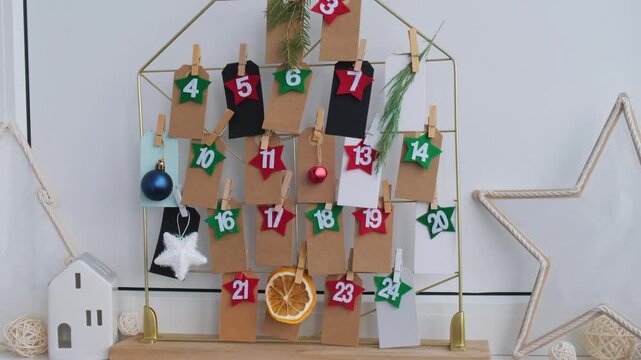 Number on craft paper notes with tasks before Christmas holidays. Female making kraft paper for handmade advent calendar Made with your own hands step by step DIY crafts do it yourself 