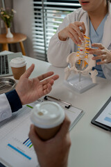 two surgeons are sitting in a private office at a hospital discussing an upcoming major pelvic surgery, there was a discussion between the two doctors about the pelvic before the surgery, stethoscope