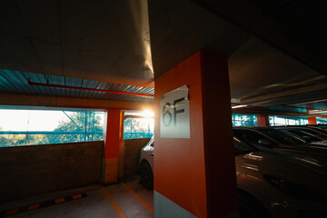 Multi storey car park in the city with afternoon sun shining on row of parked cars