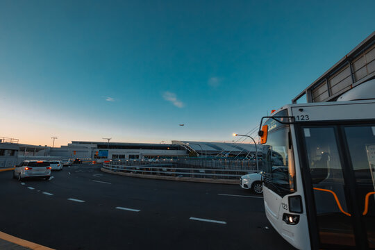 Traffic on road at Sydney Domestic Airport with plane flying overhead