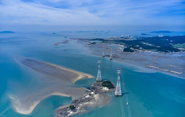 Aerial view of transmission towers with high voltage lines on uninhabited islands against a thermal power plant at Yeongheungdo Island near Ongjin-gun, South Korea