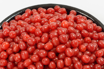 Close-up of stacked red oleaster(Elaeagnus typica) fruits on ceramic bowl on white floor, South Korea