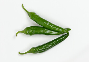 Close-up of three raw green peppers on white floor, South Korea