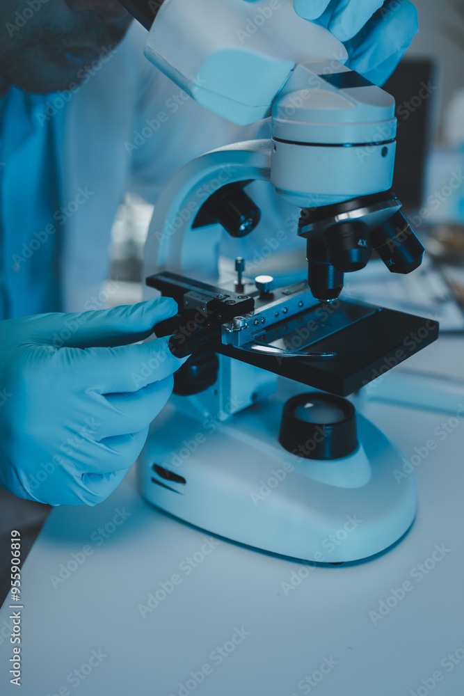 Wall mural a scientist uses a microscope to look for contaminants in a test sample, a researcher uses a microsc
