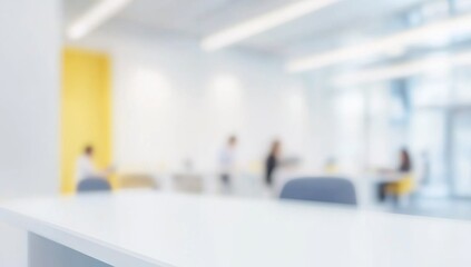 Fototapeta premium Blurred office interior with people working, featuring a modern white and light blue color scheme with yellow accents. Ideal for a business concept banner, with soft lighting and a clean, contemporary