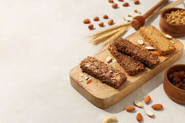 Granola bars on a wooden board with ears of corn and nuts