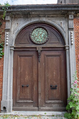 A rustic wooden door, richly adorned with intricate details, features a stunning and beautiful circular window