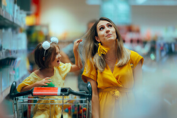 Girl Playing with Mom on a Shopping Spree in a Supermarket. Little daughter with a sense of humor...