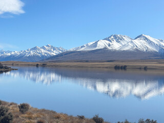 Grassy foreshore on the edge of Lake Clearwater beneath the southern alps in Hakatere conservation...