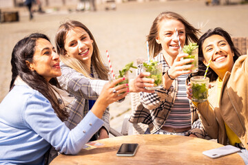 Friends having drinks outside, celebrating and relaxing in sunny weather, filled with happiness and joy