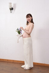 花束を持った若い日本人の妊婦