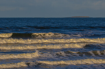 yellowish waves against a blue sky. 