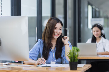 Young asian businesswoman with headset using desktop computer for customer support and online working in office, Call center helping for customers online concept.