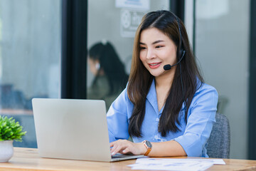 Young asian businesswoman with headset using desktop computer for customer support and online working in office, Call center helping for customers online concept.