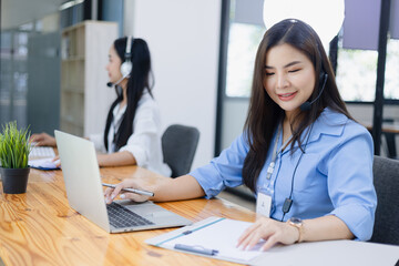 Young asian businesswoman with headset using desktop computer for customer support and online working in office, Call center helping for customers online concept.