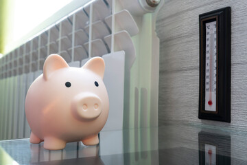 Heating thermostat with piggy bank thermometer, expensive heating costs concept