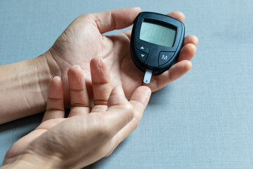 hand of people check diabetes and high blood glucose monitor with digital pressure gauge. Healthcare and Medical concept	