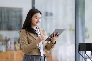 Obraz premium Young asian businesswoman using tablet to startup projects and business presentation plan.