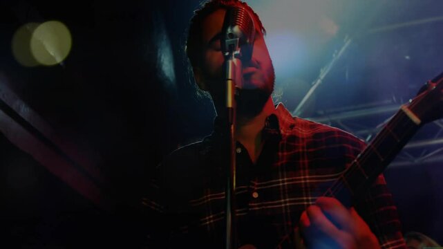 Singing and playing guitar, musician performing on stage with light effects animation