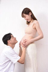 妊娠した若妻に寄り添う若い夫