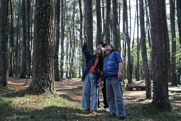 Family Members Walking Together in The Forest While Pointing Something