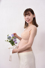 花束を持った若い日本人の妊婦