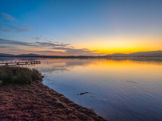 Sunrise along the waterfront with reflections on the bay water